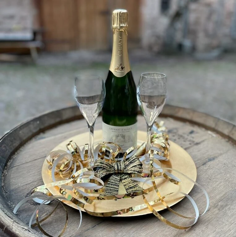 Crémant brut og to glas stillet på en tønde.